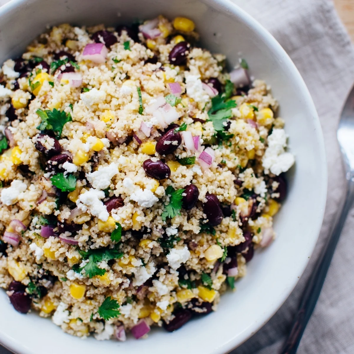 Colorful couscous salad with black beans, corn, and feta for a delightful meal.  