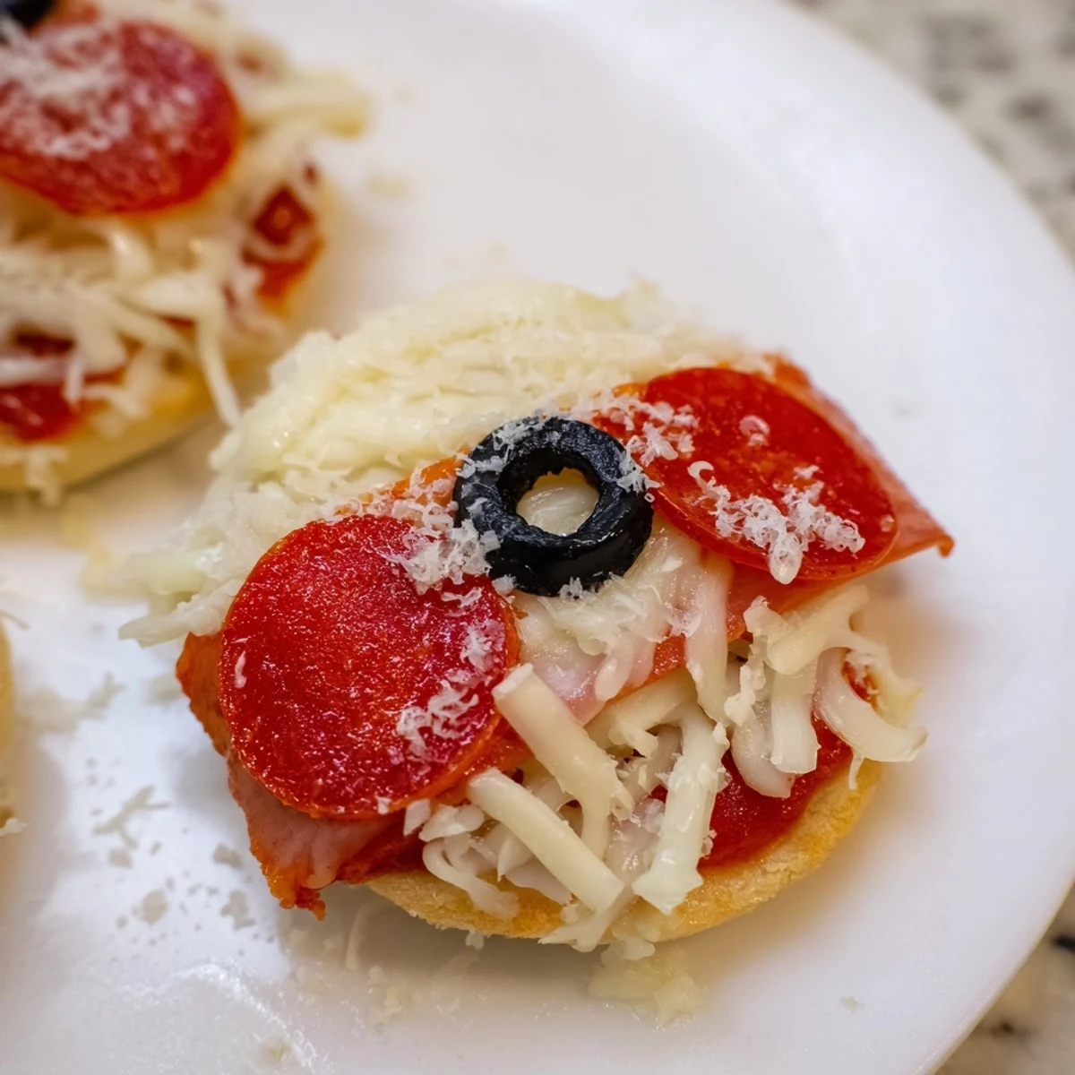 Santa Belt Mini Pizza Bites with melted mozzarella, pepperoni belts, and olives ready to eat.