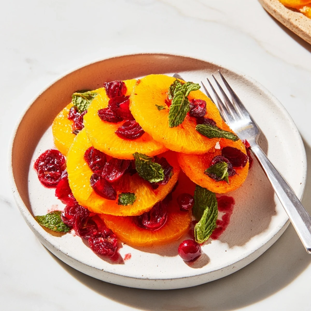 A colorful close-up of winter fruit showcases juicy orange slices with bright red cranberries, perfect for a side.