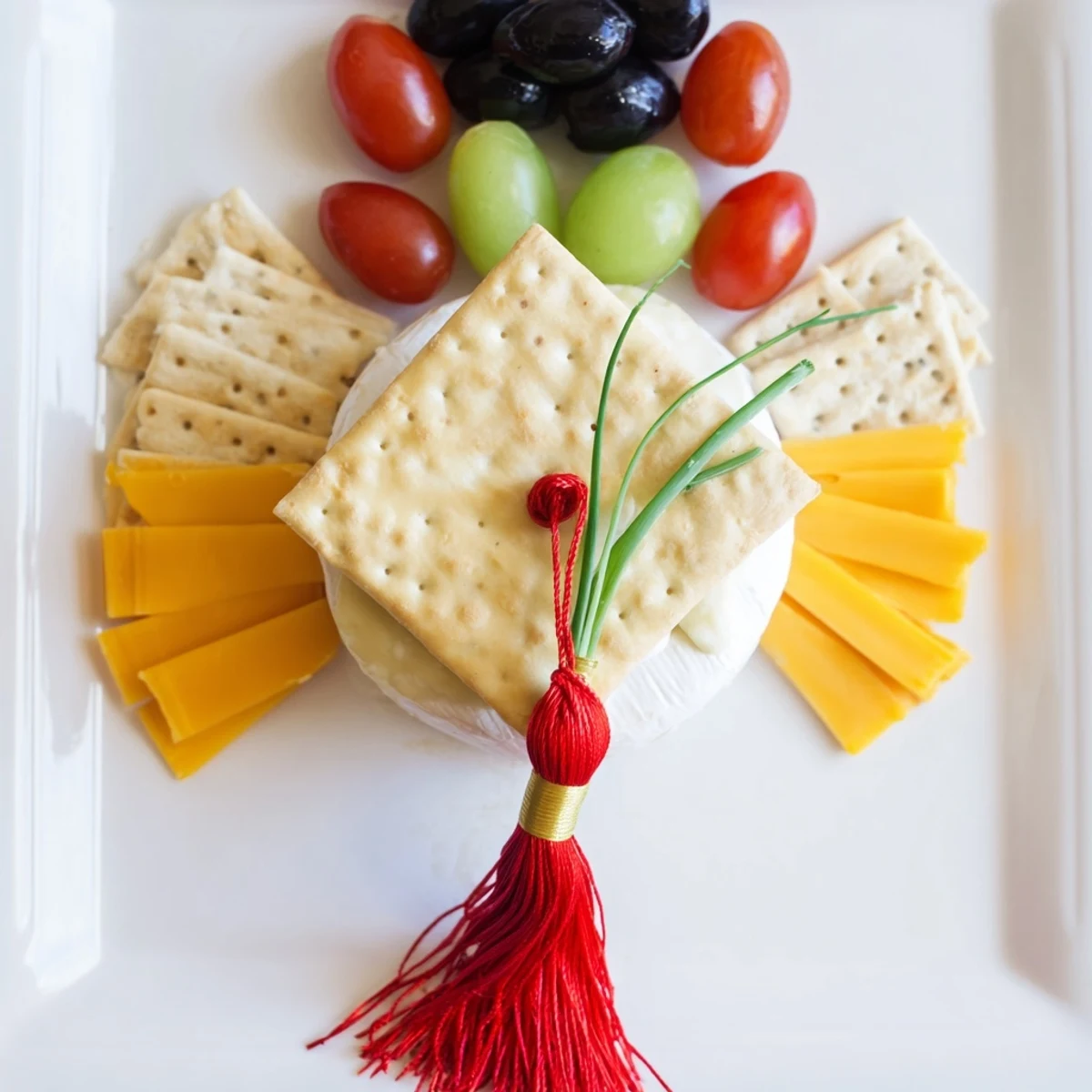 Beautiful Graduation Cap Platter appetizer with cheddar cheese, olives, and grapes; perfect for your grad party.
