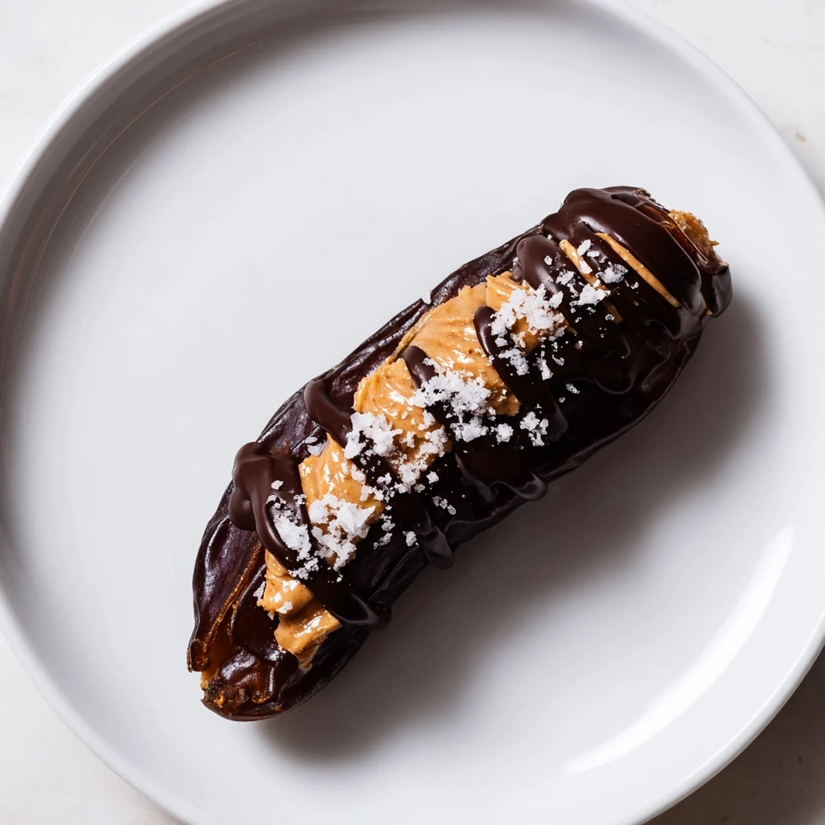 Close-up of freshly made Chocolate Peanut Butter Dates, showcasing the creamy peanut butter filling and sea salt.