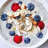Vibrant poppy seed chia pudding topped with raspberries and coconut, served in a rustic ceramic bowl.