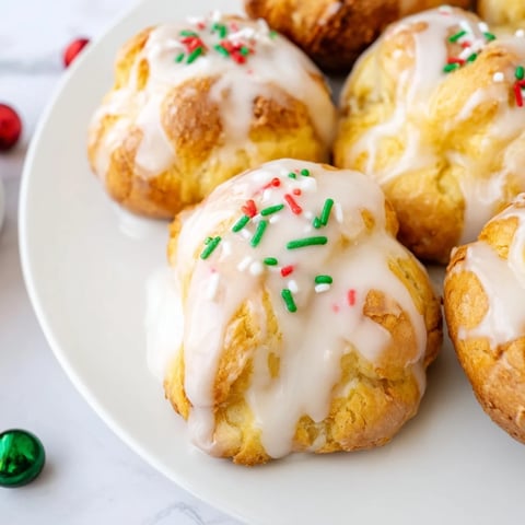 Quick Christmas Biscuit Bombs, fresh from the oven, glistening with a creamy glaze and sprinkles.