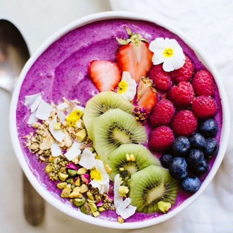 Bright smoothie bowls featuring purple yam and pistachios for a delightful breakfast treat.  