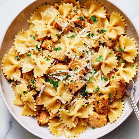 Creamy Mozzarella Garlic Butter Chicken Bowties garnished with fresh parsley and Parmesan cheese.  