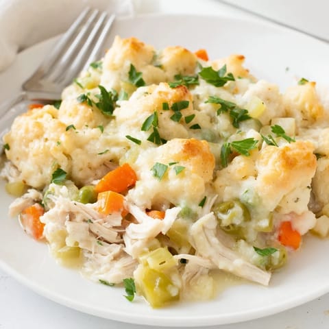 Golden Chicken and Dumplings Casserole topped with fluffy dumplings and fresh parsley.  