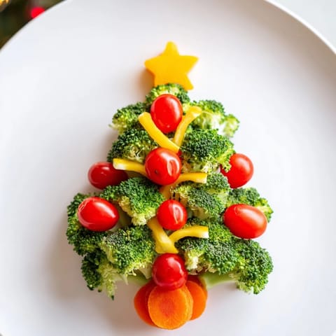Festive Broccoli Tree appetizer, showcasing cherry tomato decorations and yellow pepper "garland" on a platter.