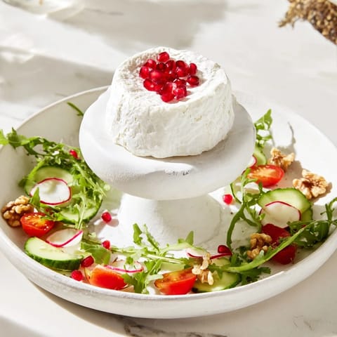 Vibrant The Zenith Point salad showcasing colorful fresh produce radiating from soft cheese.