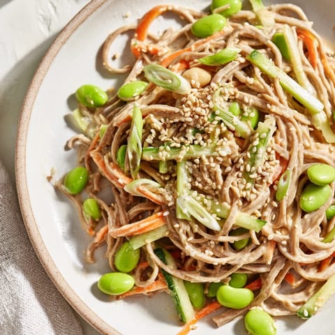 Cool, refreshing Asian Sesame Noodle Salad with visible sesame seeds in a creamy, glossy dressing.