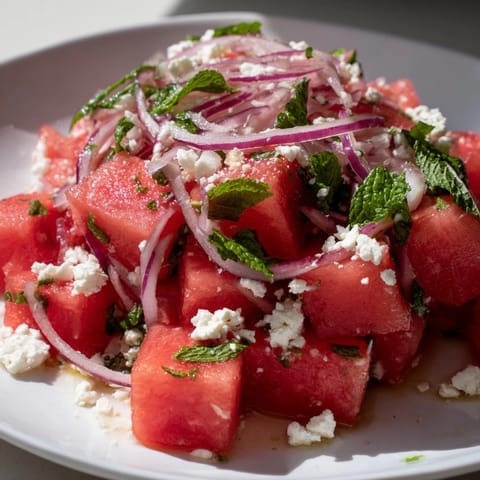 Bright, colorful view of Watermelon Feta Salad, featuring sweet melon, crumbled feta, and zesty dressing.