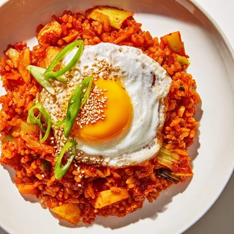 Close-up of vibrant kimchi fried rice with colorful veggies and sesame seeds, a comforting Korean meal.
