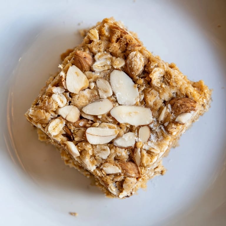 Close-up on chewy Protein Cinnamon Almond Squares; sprinkled with toasted almond slices, ready to eat.