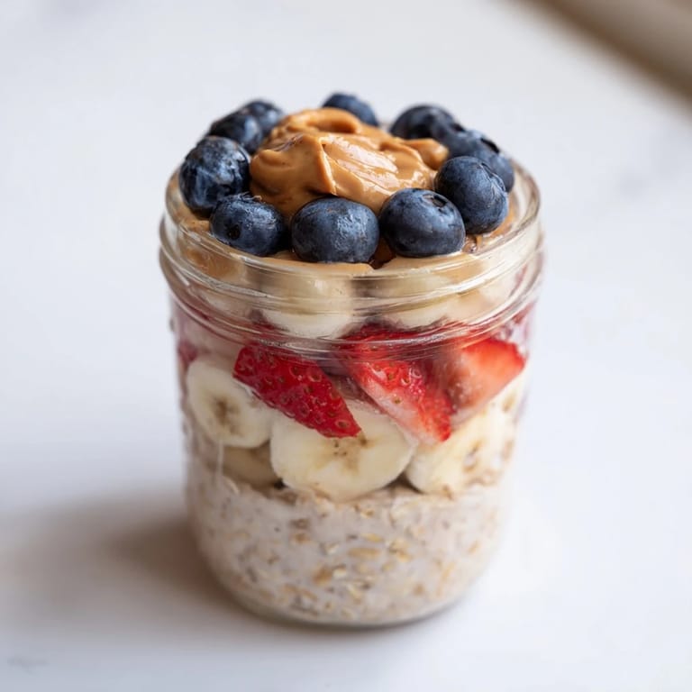 A close-up of delicious Overnight Oats jars, showcasing the fresh fruit and peanut butter swirls, ready to eat.