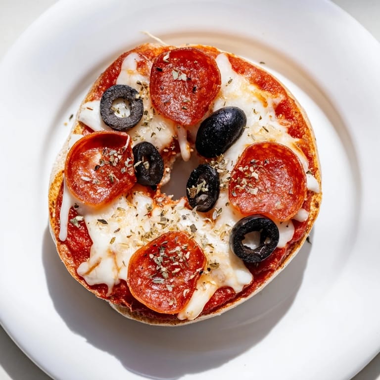 A close-up of cheesy mini bagel pizzas fresh from the air fryer, ready to be enjoyed.