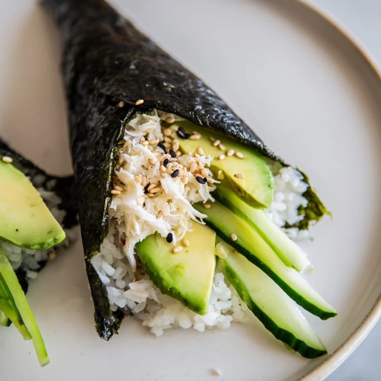 Close-up of freshly made sushi rice hand rolls with colorful fillings, ready for dipping and eating.